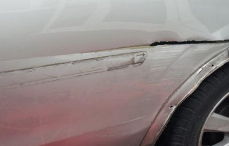 Close-up of damage on side of car