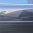 Close-up of dents on the doors on the side of a blue car